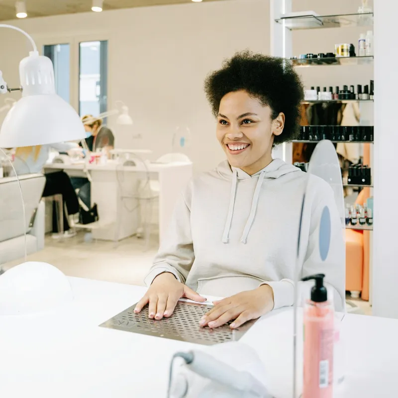 Nail technician working on client